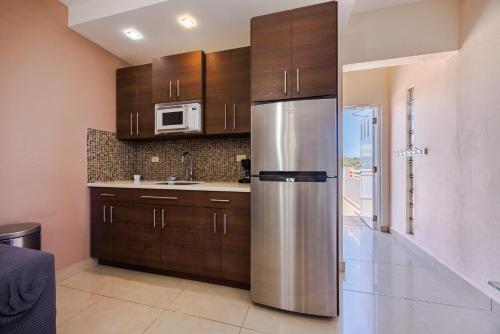 a kitchen with wooden cabinets and a stainless steel refrigerator at Ulala Culebra in Culebra