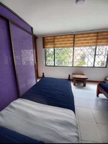 a bedroom with a large bed and two windows at centro bogota in Bogotá