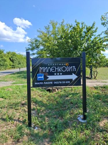 a sign in the grass next to a road at Apartman Milenkovic in Malo Laole