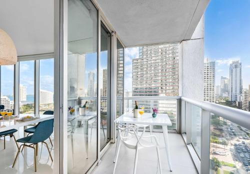 an apartment balcony with tables and chairs and a view of the city at MVR - Direct Bay View - Corner Smart TV in Miami