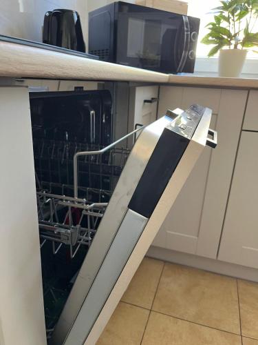 a dishwasher with its door open in a kitchen at Apartament Piaskowa Mountain & Coffee in Wałbrzych