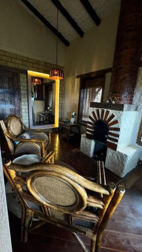 a living room with chairs and a couch and a fireplace at Hotel Boutique Guatika in Tibasosa