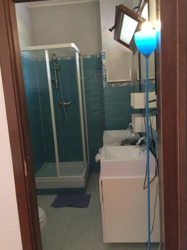 a bathroom with a shower and two sinks and a toilet at Villa DonnAnna in Cariati