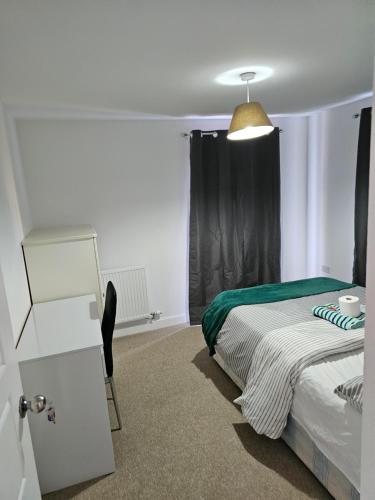 a bedroom with a bed and a chair and a lamp at Double Cosy bedroom in central Dartford-Close to all amenities in Dartford