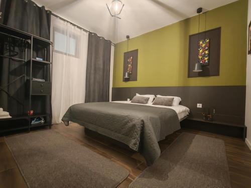 a bedroom with a large bed with green walls at Best City Green in Craiova