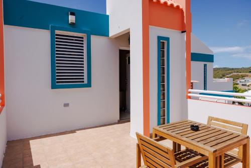 a small balcony with a wooden table and chair at Ulala Culebra in Culebra