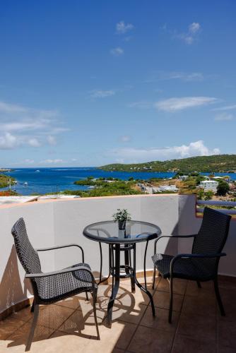 a table and chairs on a balcony with a view of the ocean at Ulala Culebra in Culebra