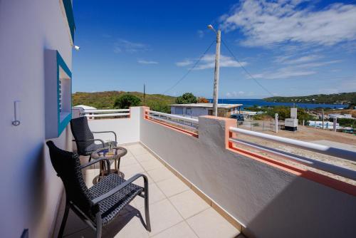 a balcony with two chairs and a view of the ocean at Ulala Culebra in Culebra