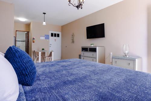 a bedroom with a blue bed with a tv on the wall at Ulala Culebra in Culebra