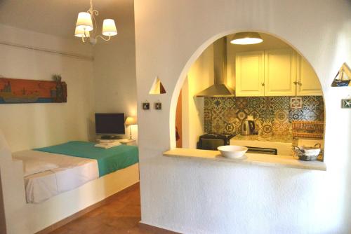 una cucina con un lavandino e un letto in una stanza di Anofli Suites a Skopelos Town