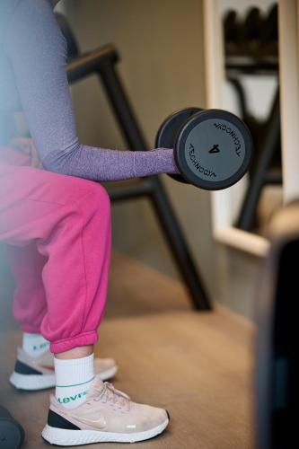 a person in pink pants holding a barbell at Hotel Gasthof Krönele in Lustenau