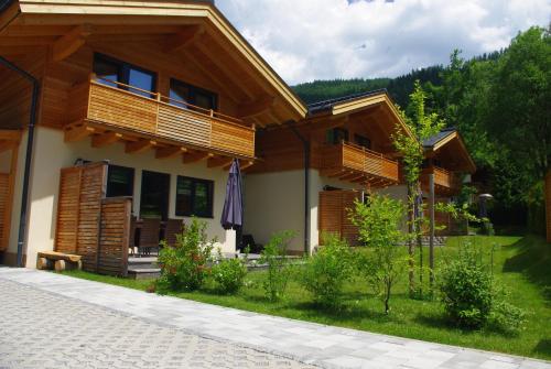 a house with wooden balconies on the side of it at Chalets AurAlpin in Kleinarl