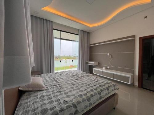 a bedroom with a large bed and a large window at Casa COP 30 alto padrão in Santa Isabel do Pará