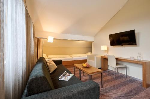 a living room with a couch and a table at Hotel Gasthof Krönele in Lustenau