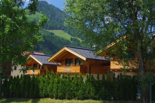 a log cabin in the mountains with a fence at Chalets AurAlpin in Kleinarl