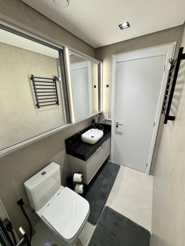a bathroom with a white toilet and a sink at Studio b2b in Florianópolis