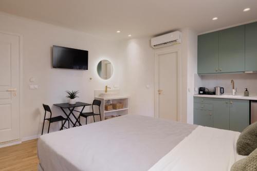 ein Schlafzimmer mit Bett und eine Küche mit Tisch in der Unterkunft Dousmani Old Town Studio in Korfu-Stadt