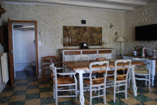 a dining room with a wooden table and chairs at La caburoche de Charlemagne in Civray-de-Touraine