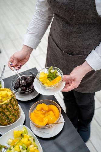 a person holding a bowl of fruit on a table at Hotel Giotto in Padova