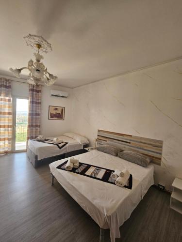 a bedroom with two beds and a chandelier at B&B IL Pistacchio in Agrigento
