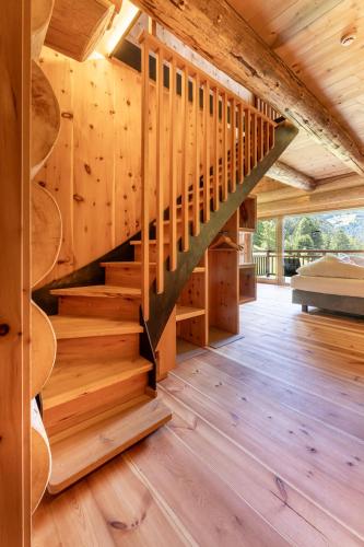 a wooden staircase in a cabin with wooden floors at Boutique Hotel Pradell in Ortisei