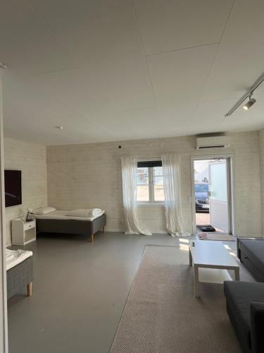 a large white room with a bed and a couch at Sjöhuset in Ellös