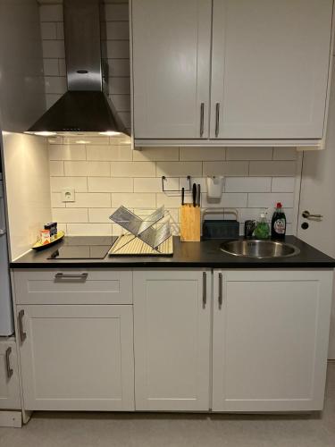a kitchen with white cabinets and a sink at Sea and city in Billdal