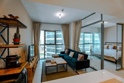a living room with a couch and a bed at Modern Glass Suite with City Views Reem Island in Abu Dhabi