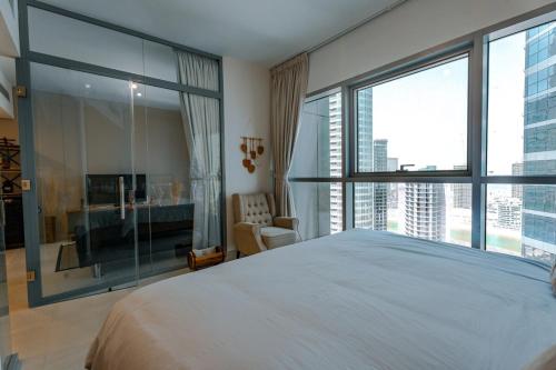 a bedroom with a large bed and large windows at Modern Glass Suite with City Views Reem Island in Abu Dhabi
