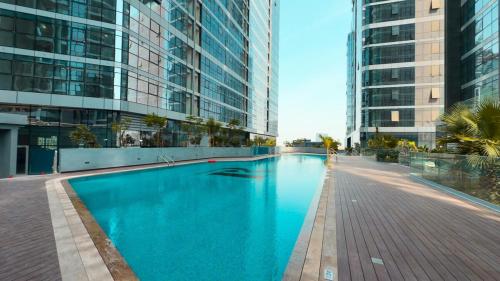 a large swimming pool in a building with tall buildings at Modern Glass Suite with City Views Reem Island in Abu Dhabi