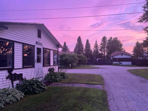 a white house with a sunset in the background at Relax with mountain views & a hot tub #5 in Carroll
