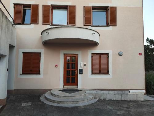 a building with a red door and windows at Prenočišča Center Mir In Dobro in Solkan