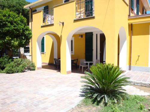 a yellow house with arches and a patio at Andoramare B&B in Marina di Andora