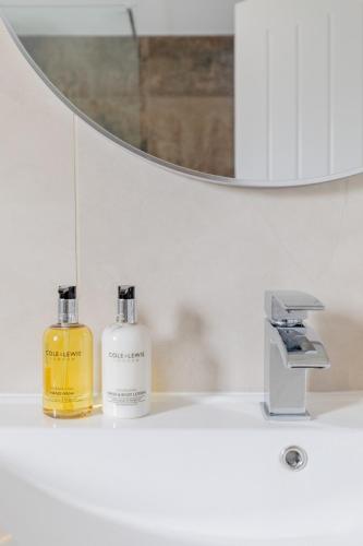 a bathroom with two bottles of soap on a sink at Elegant One bedroom Apartment in Hounslow in Hounslow