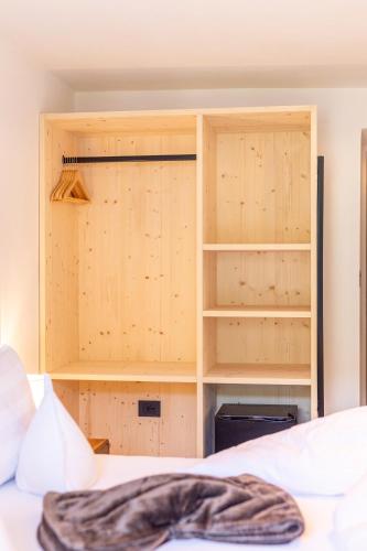 a room with a bed and a cupboard at Boutique Hotel Pradell in Ortisei