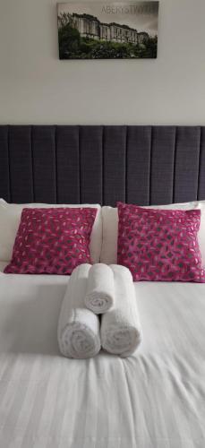 a bed with two towels and two pillows on it at Luxury Sea View Apartment - One Bedroom in Aberystwyth