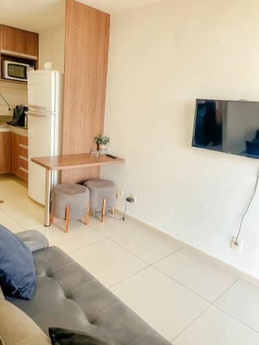 - un salon avec un canapé, une table et un réfrigérateur dans l'établissement DF PLAZA - Lindo apartamento com suíte!, à Brasilia