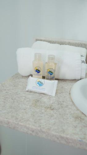 two glasses of milk and towels on a bathroom counter at Hotel Rio de Pedras in Itabirito