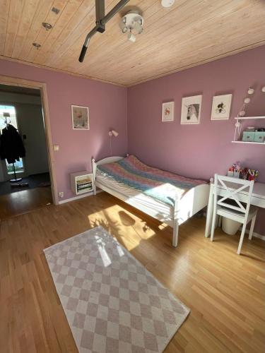 a bedroom with a bed and a purple wall at Holiday home close to forest, lake and skiing in Ulricehamn