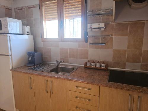 a small kitchen with a sink and a refrigerator at CASA RURAL LLAVADOR Vall Guadalest in Benifató