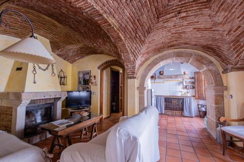 a living room with an arch ceiling with a fireplace at Casa Rural El Fontano CR-CC-182 in Montánchez