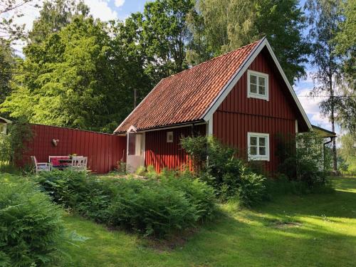 TrensumForrest cottage by the lake的红色谷仓,有红色屋顶