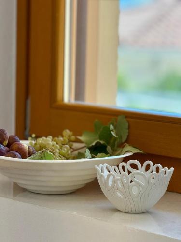 a bowl of grapes and a bowl of fruit on a counter at The Jazz Suite in Aegina Town
