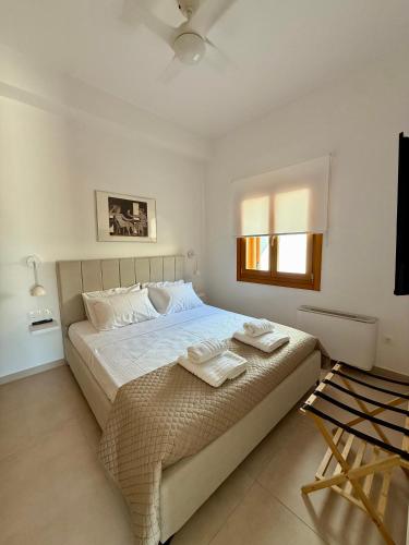 a bedroom with a large bed with two towels on it at The Jazz Suite in Aegina Town