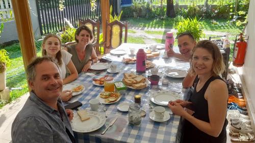 a group of people sitting around a table eating food at Le Meridien BnB in Negombo