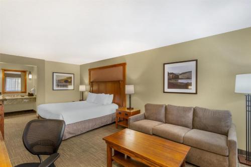 a hotel room with a bed and a couch at Best Western Plus High Country Inn in Ogden