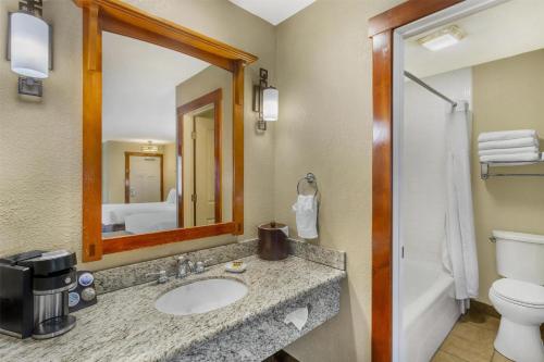 a bathroom with a sink and a toilet and a mirror at Best Western Plus High Country Inn in Ogden