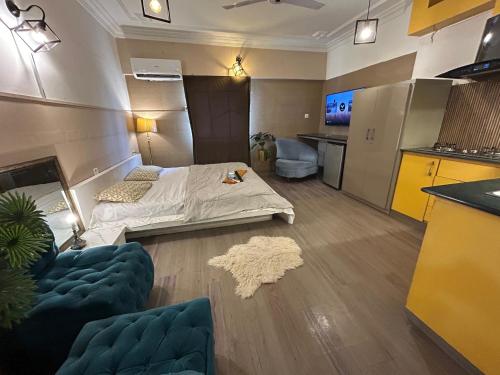 a small room with a bed and a kitchen at amstredam in Karachi