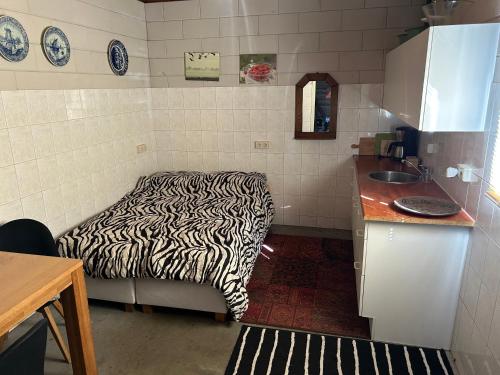 a kitchen with a zebra print bed in a room at Simpel overnachten in Langeveen