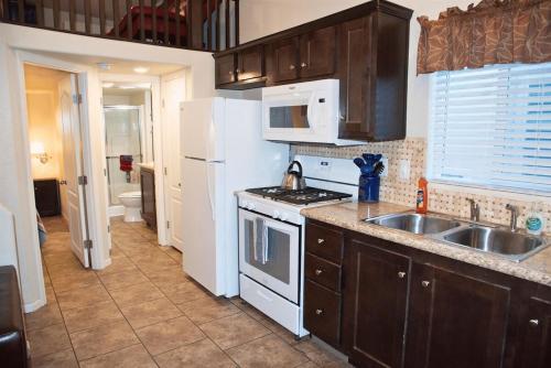 a kitchen with a sink and a white refrigerator at Portal Overlook Cabin #14 in Moab